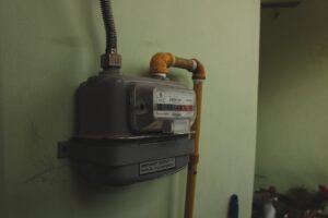 home gas meter and piping with safety signage outside a modern residential home - how to prevent gas leaks in your home